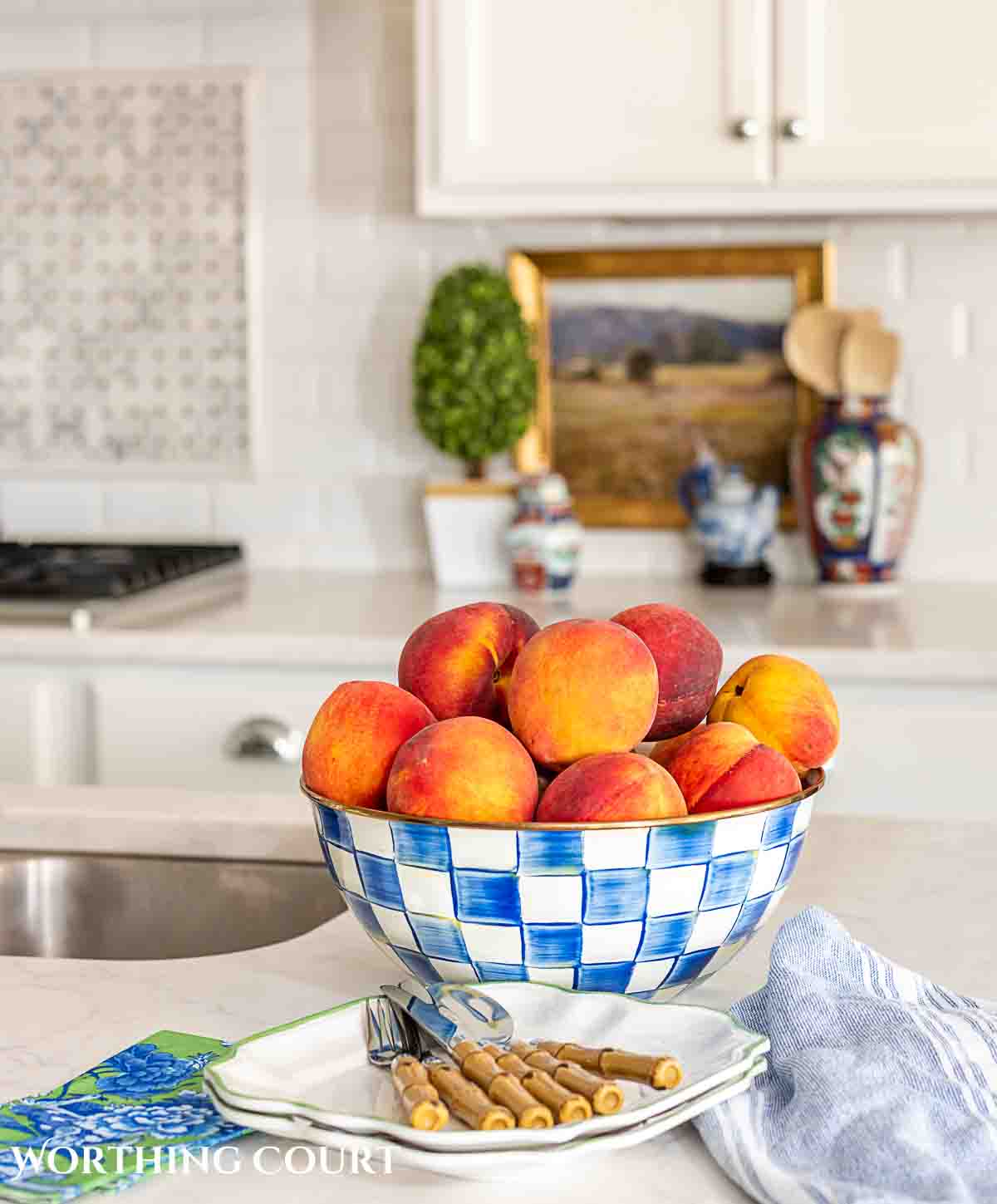 ripe peaches in a blue and white check bowl in a kitchen