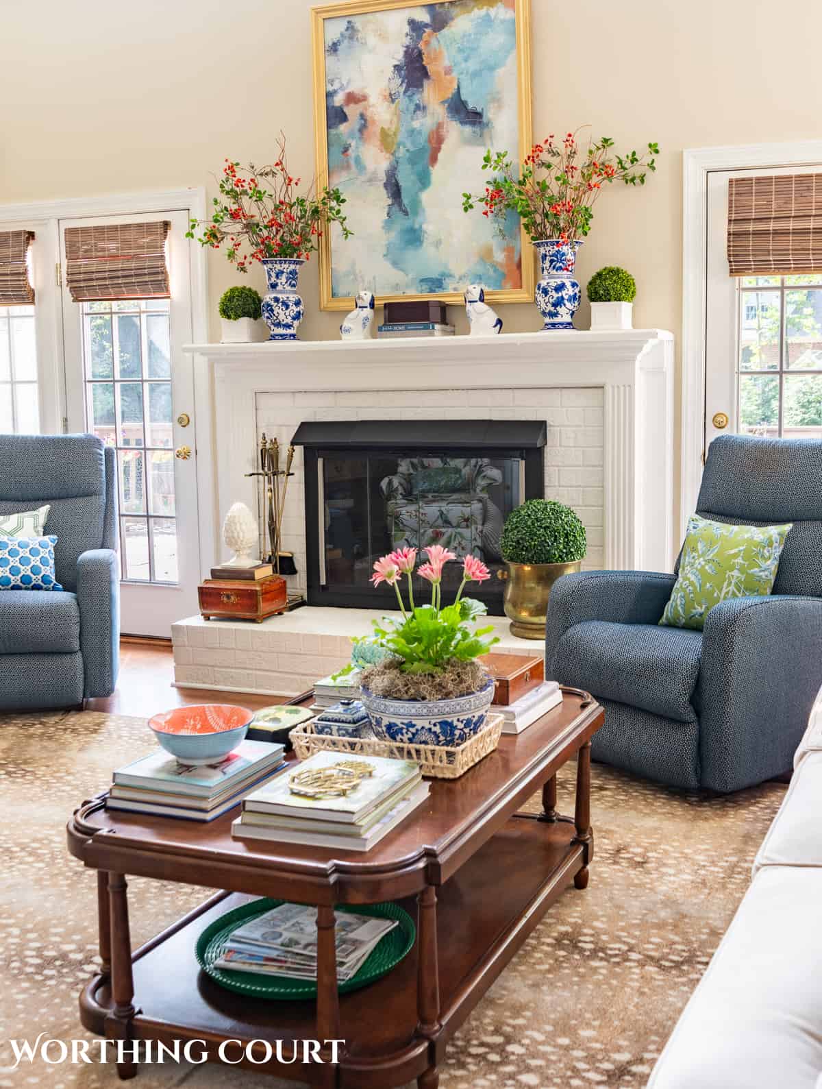 wood coffee table with late summer accessories in front of a white brick fireplace and blue chair