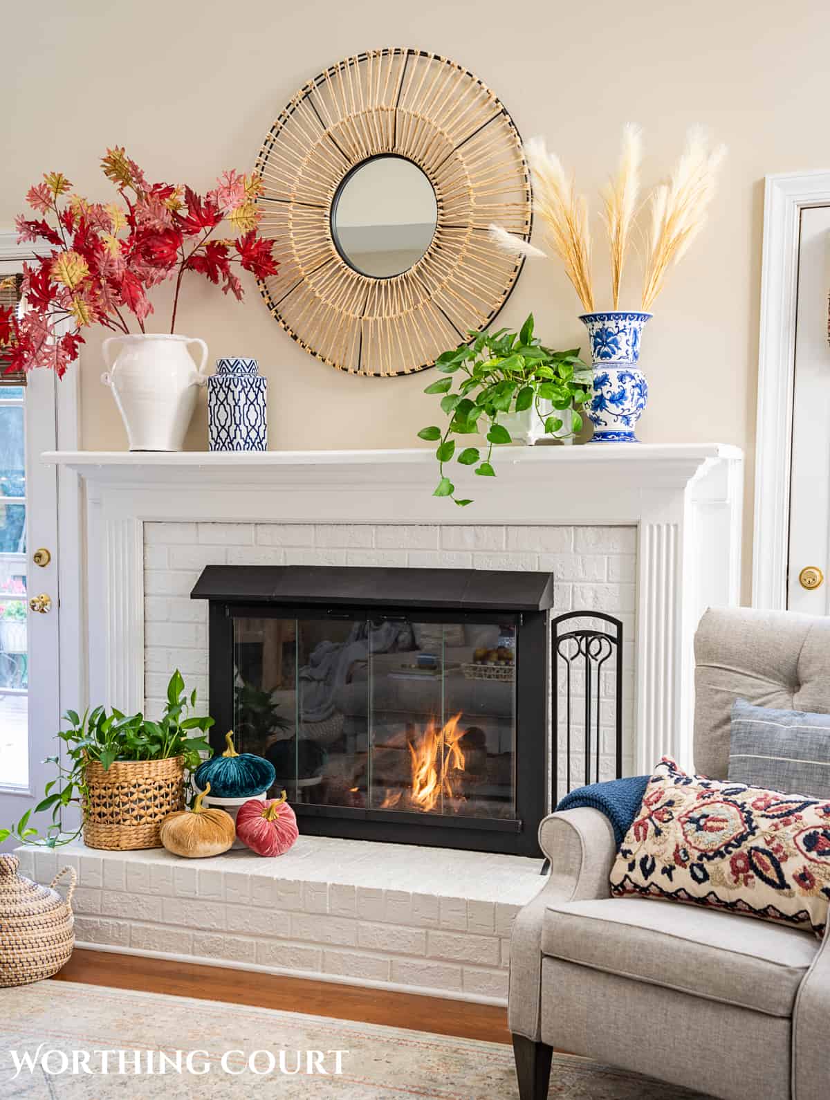 fall decorations on a white brink fireplace and mantel