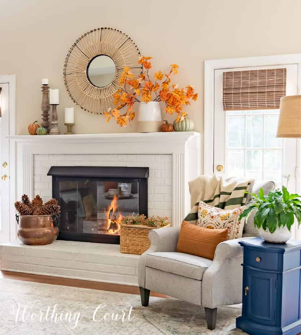 fall decorations on a white brink fireplace and mantel