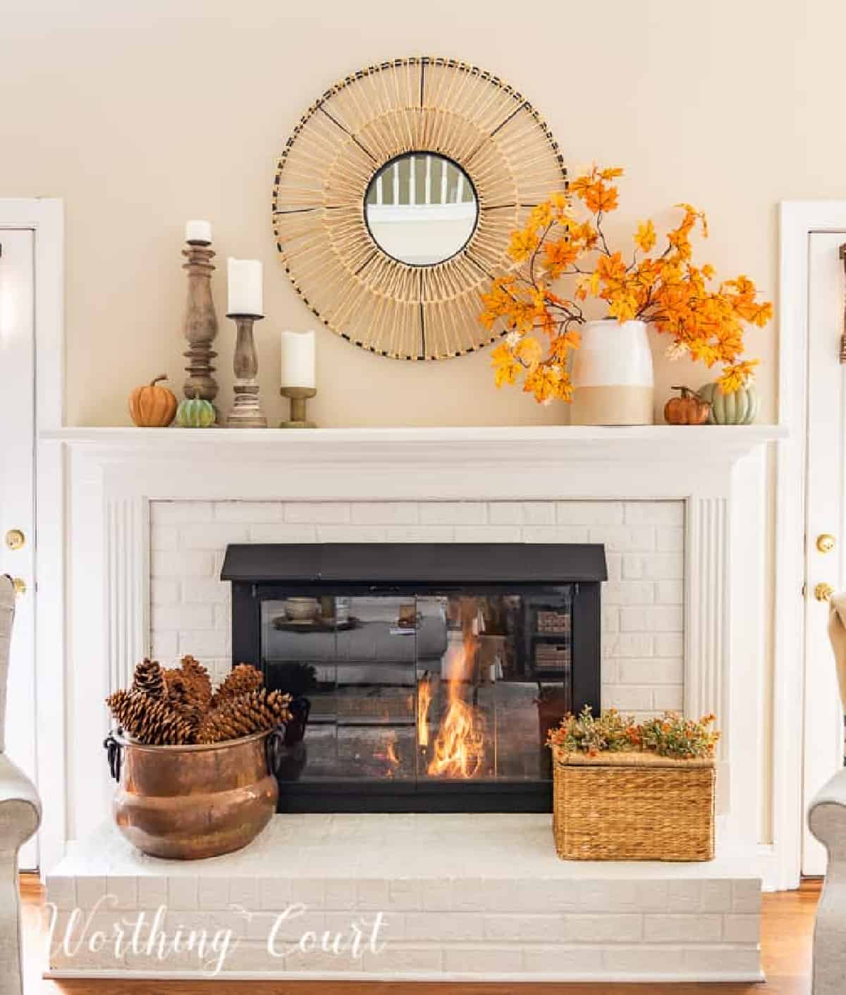 fall decorations on a white brink fireplace and mantel