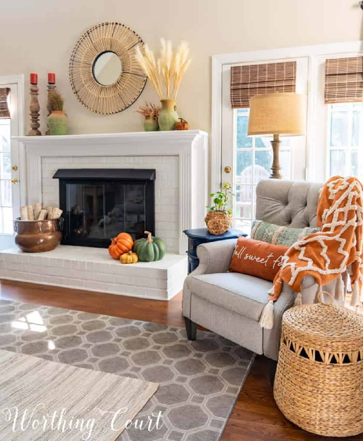 fall decorations on a white brink fireplace and mantel