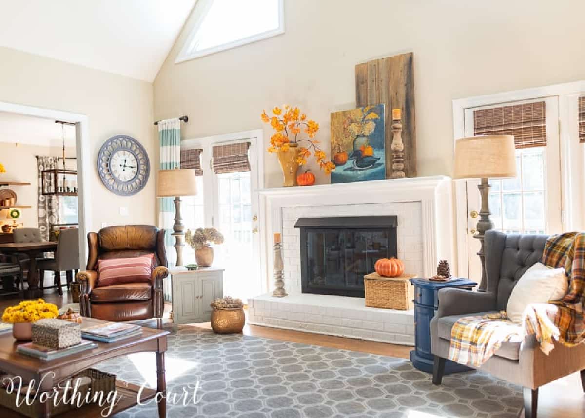 fall decorations on a white brink fireplace and mantel