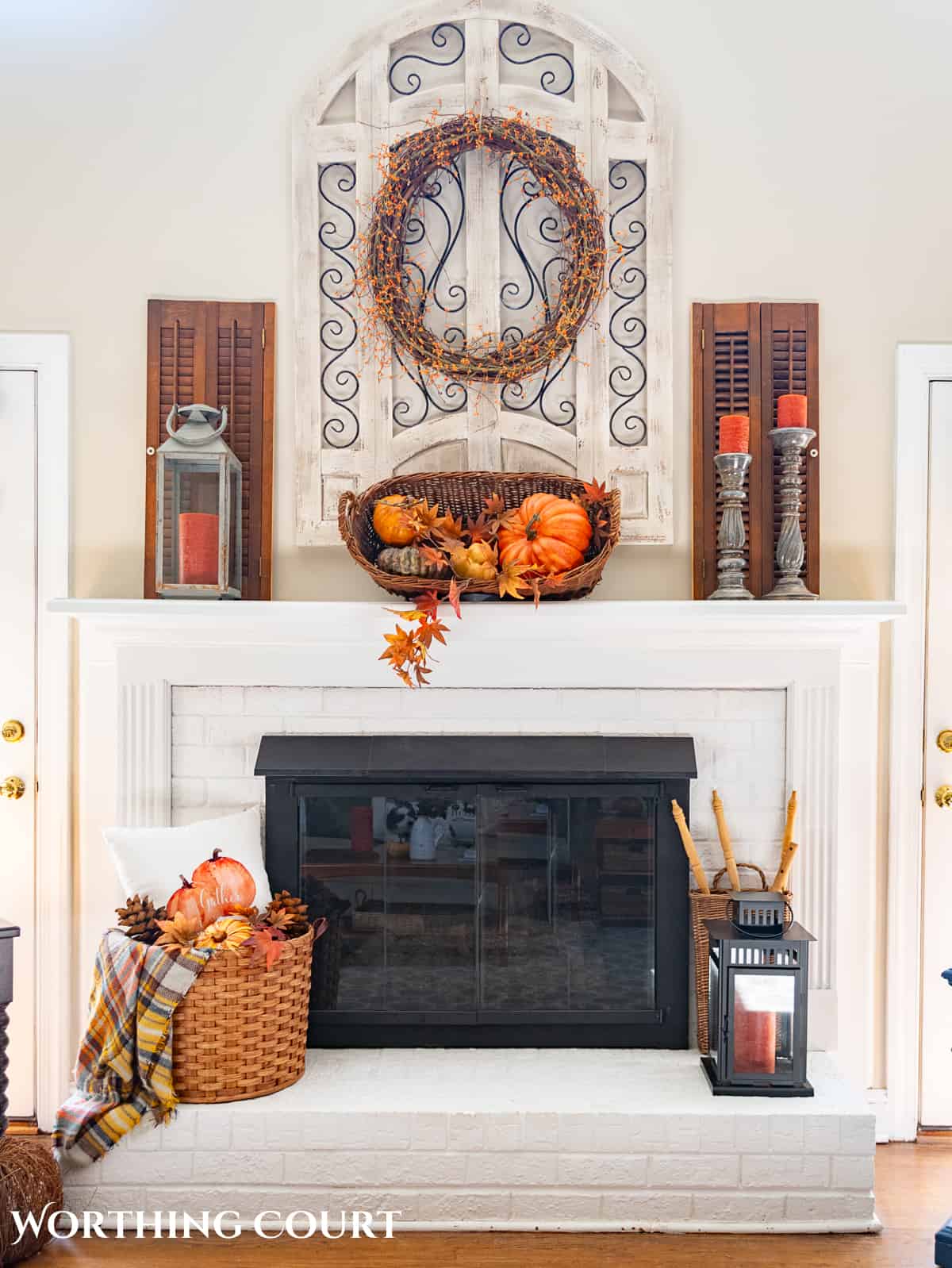 fall decorations on a white brink fireplace and mantel