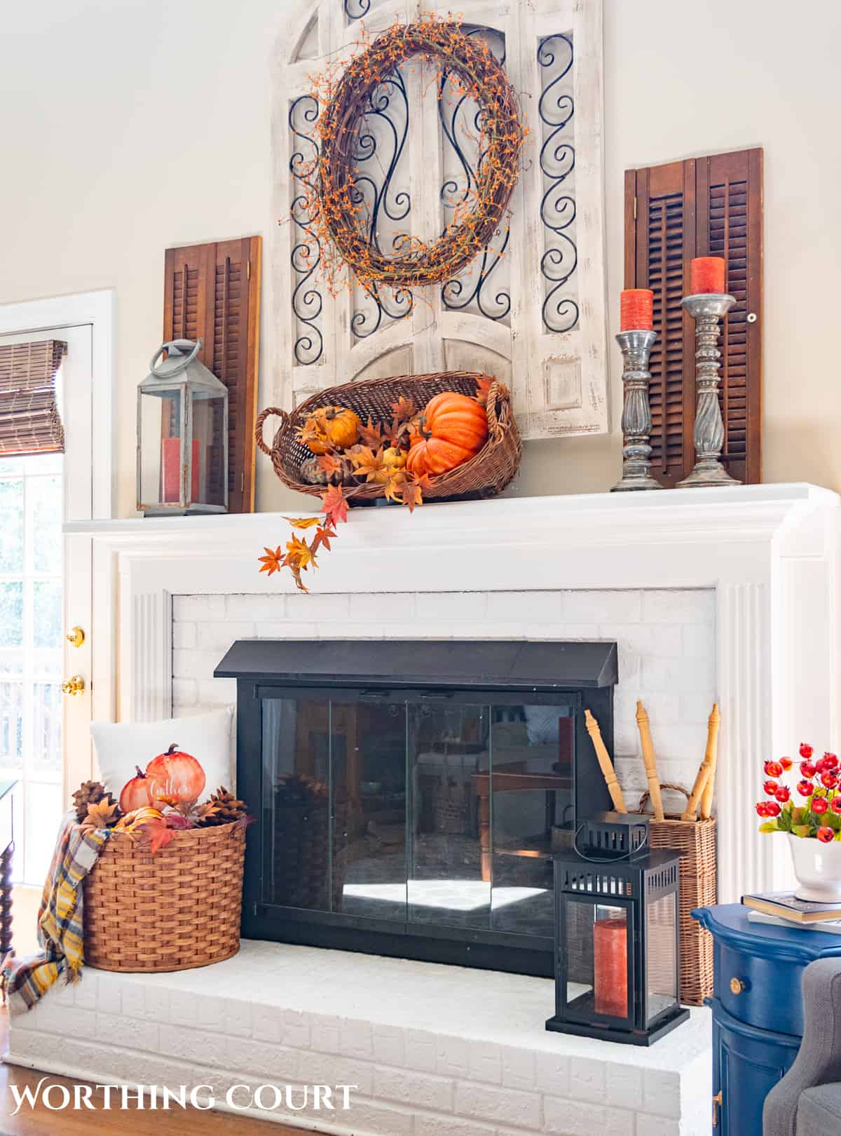 fall decorations on a white brink fireplace and mantel