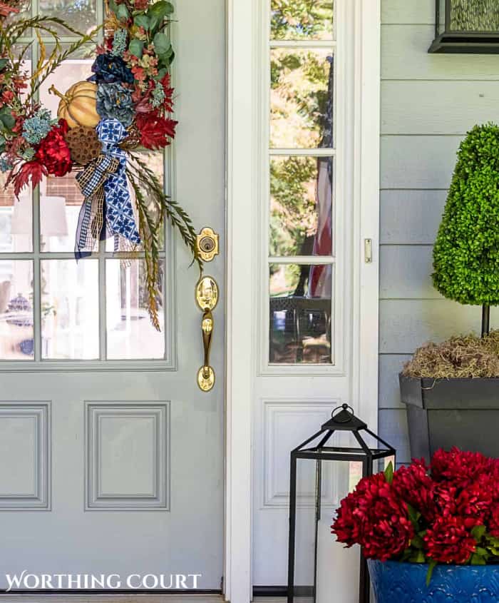 partial view of a front door and porch with burgundy and blue fall decorations