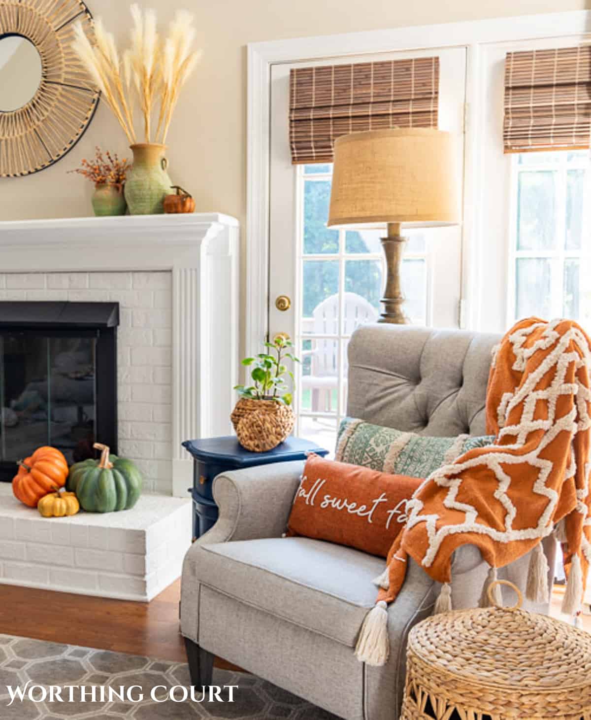 plush fall throw blanket over a gray arm chair in front of a fireplace with fall decor to demonstrate a fall aesthetic