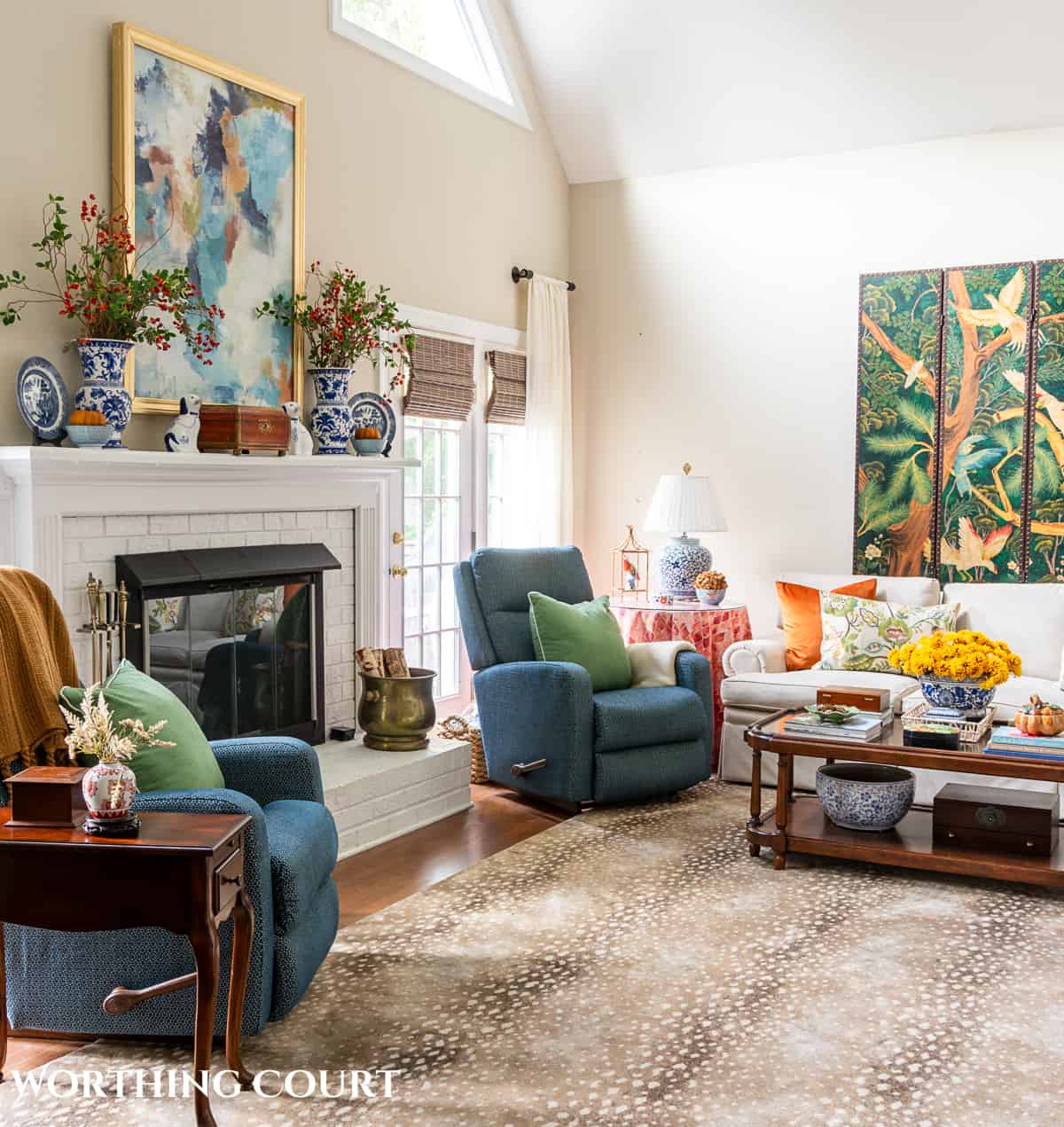 blue arm chairs flanking a white brick fireplace in a living room with fall decorations