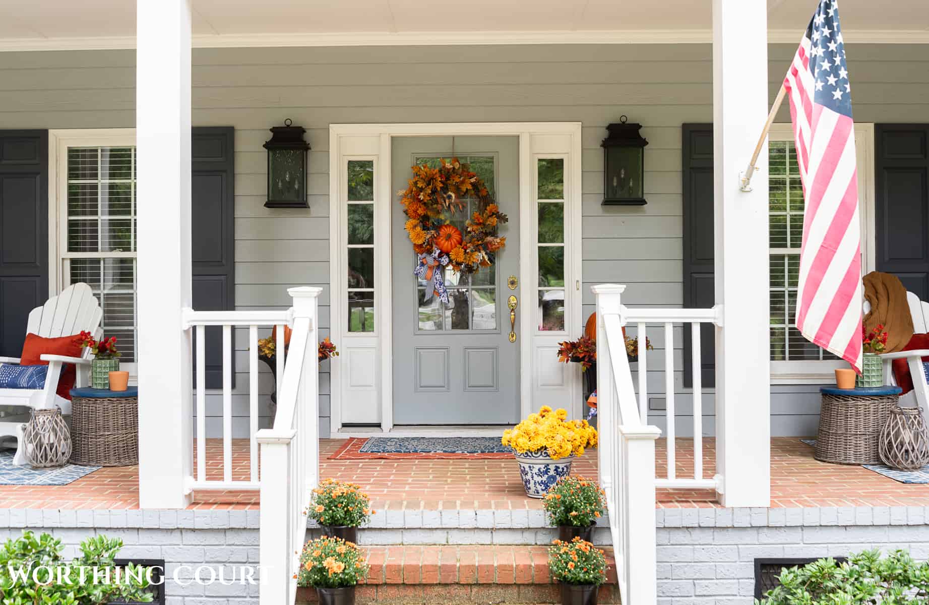 brick steps leading up to a large front porch decorated for fall