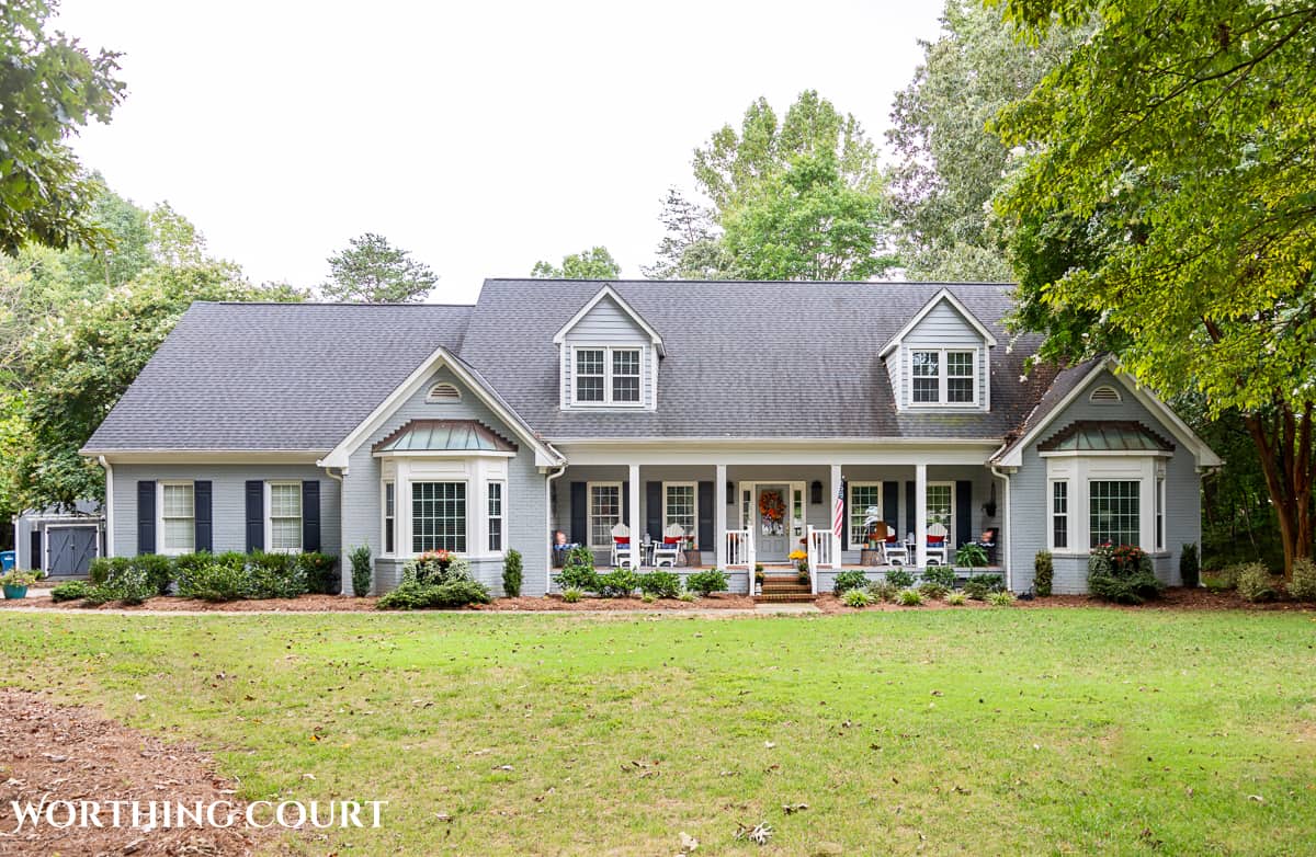 exterior of gray house with a large front porch decorated for fall