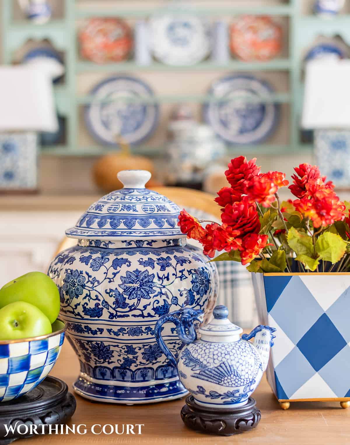 fall centerpiece using blue and white containers filled with fall floral stems and green apples in a bowl