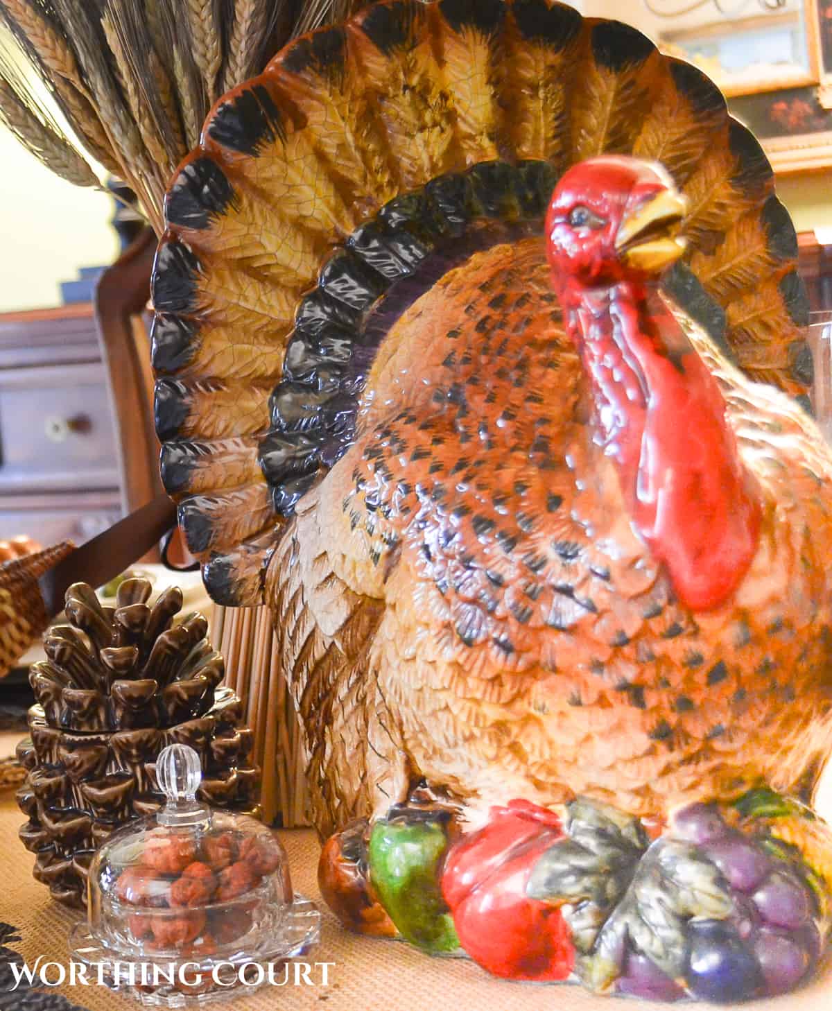 Large ceramic turkey on a woodland themed Thanksgiving table setting.