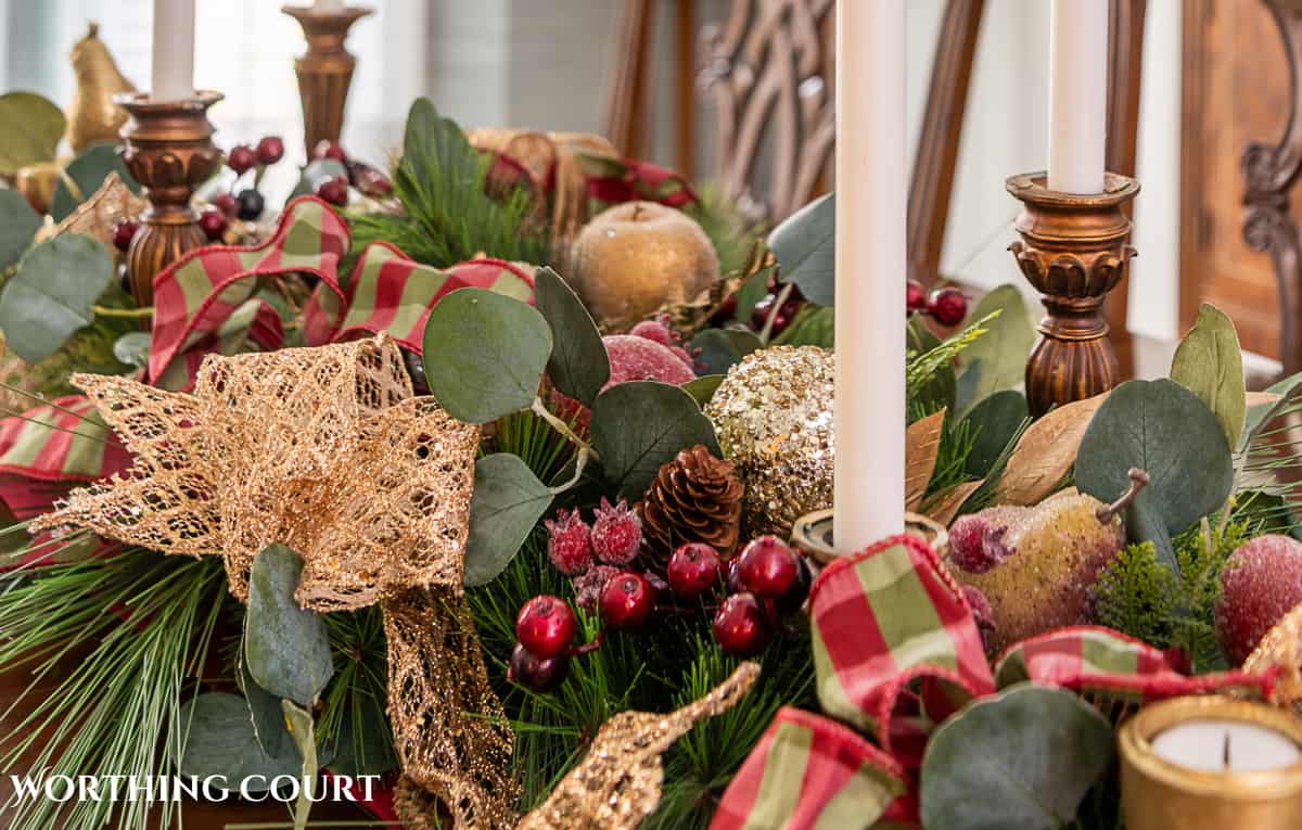 An elegant, but easy Christmas centerpiece made with faux greenery and sugared fruit swags. Includes green, burgundy and gold ribbon, gold candlesticks and white candles.