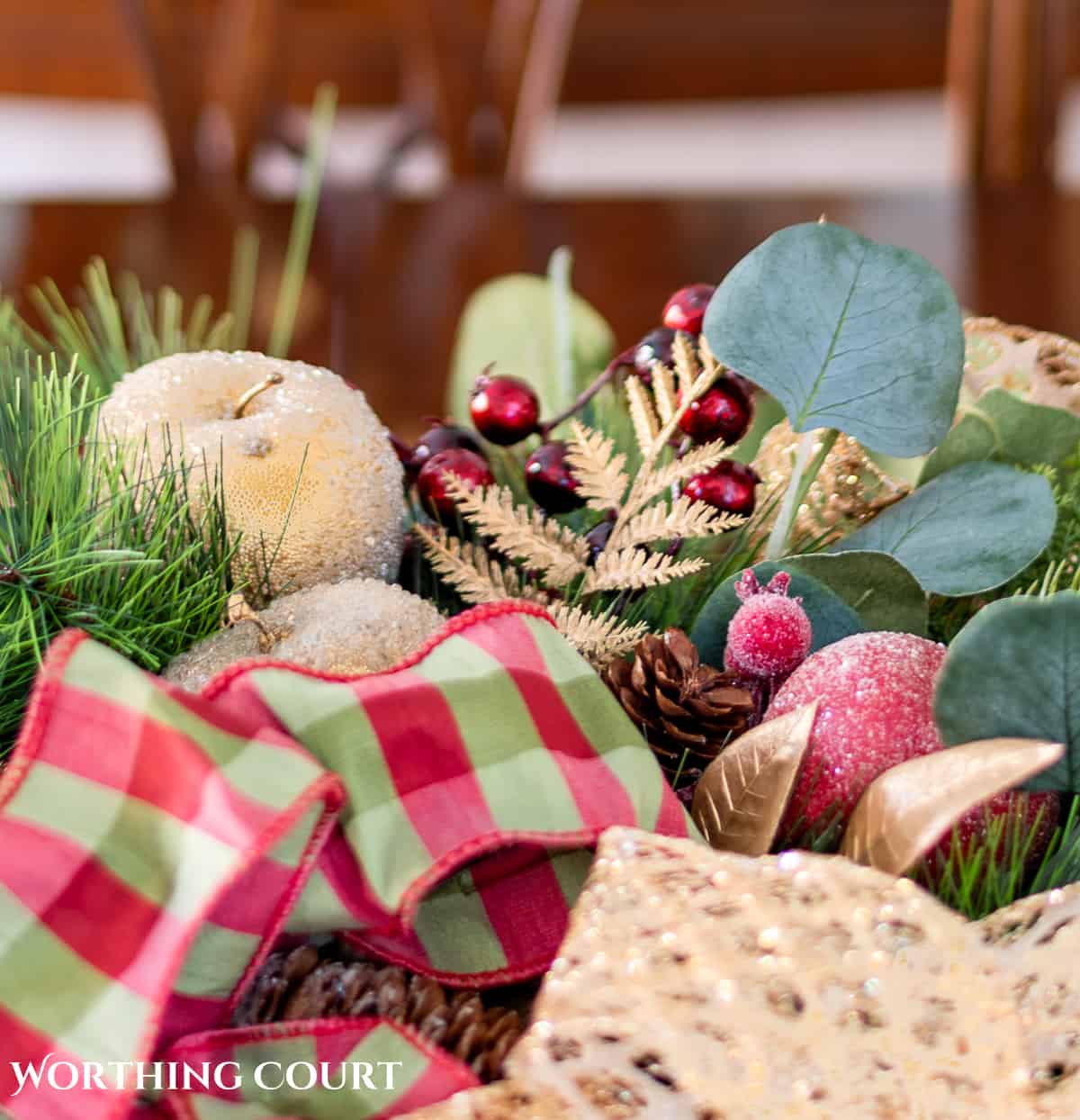 An elegant, but easy Christmas centerpiece made with faux greenery and sugared fruit swags. Includes green, burgundy and gold ribbon, gold candlesticks and white candles.