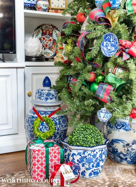 gifts at base of Christmas tree with traditional decorations and presents wrapped in colorful Christmas wrapping paper