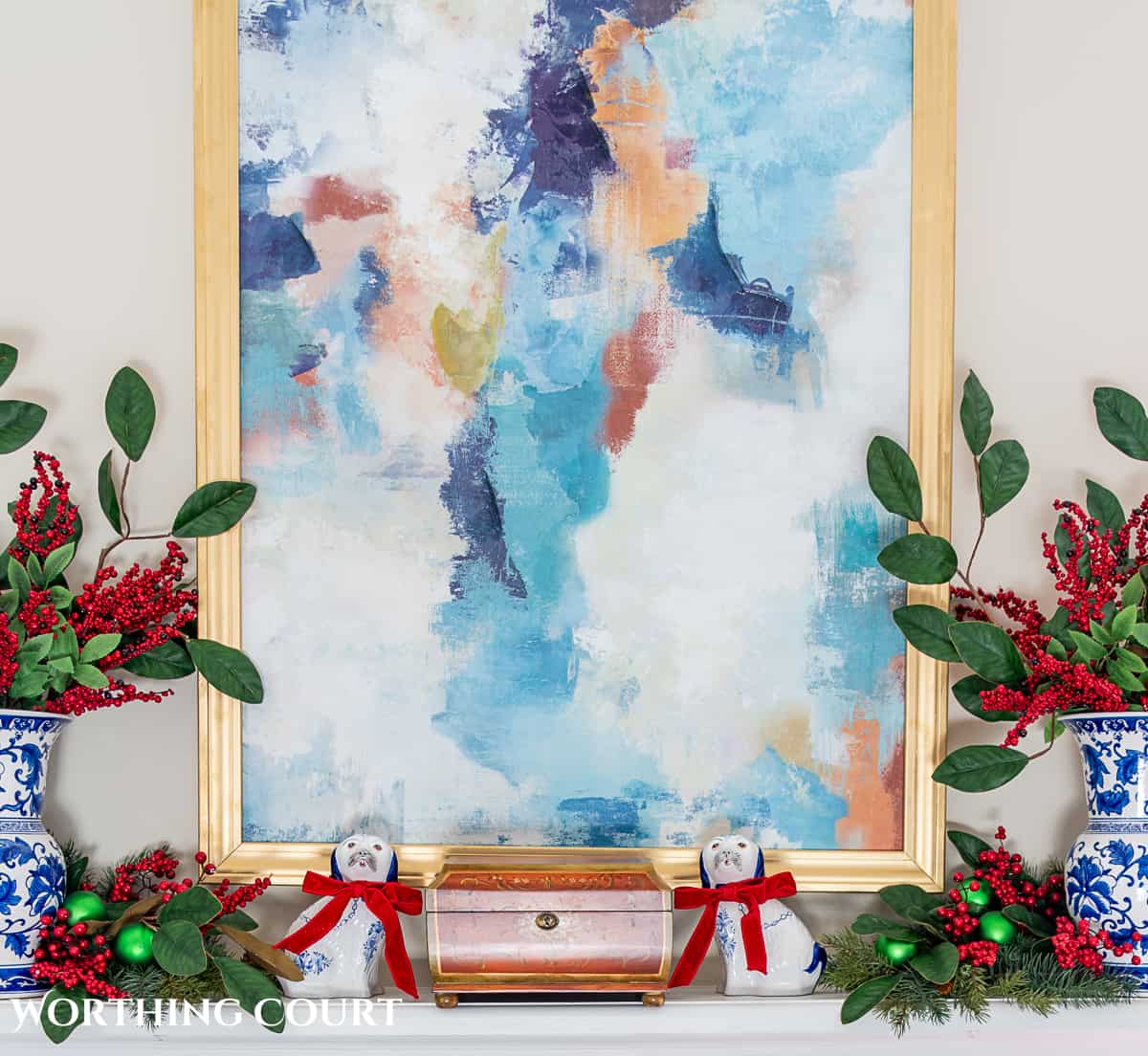 fireplace mantel with abstract art above and traditional Christmas decorations mixed with chinoiserie decor items
