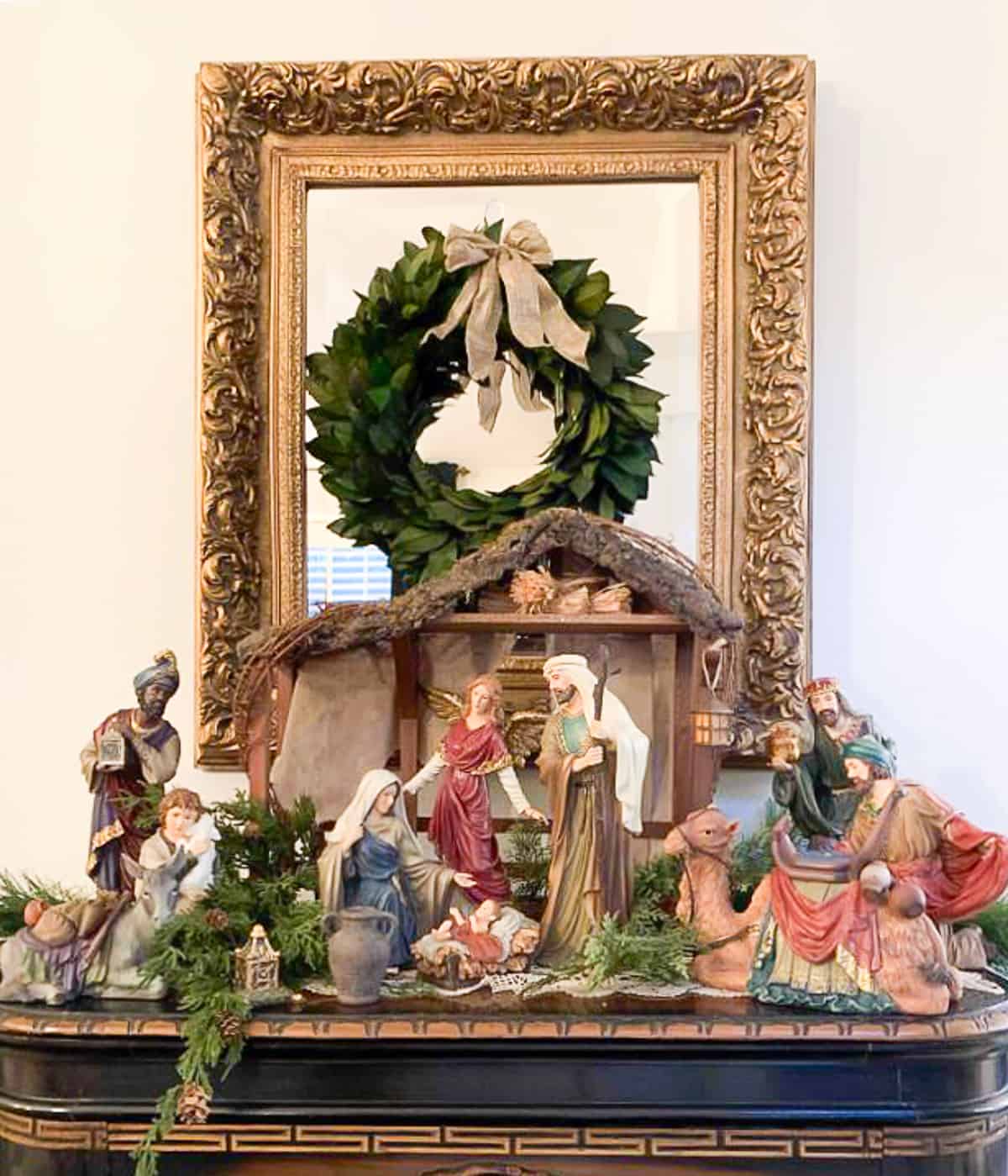 traditional style nativity scene on a chest with a mirror hanging above