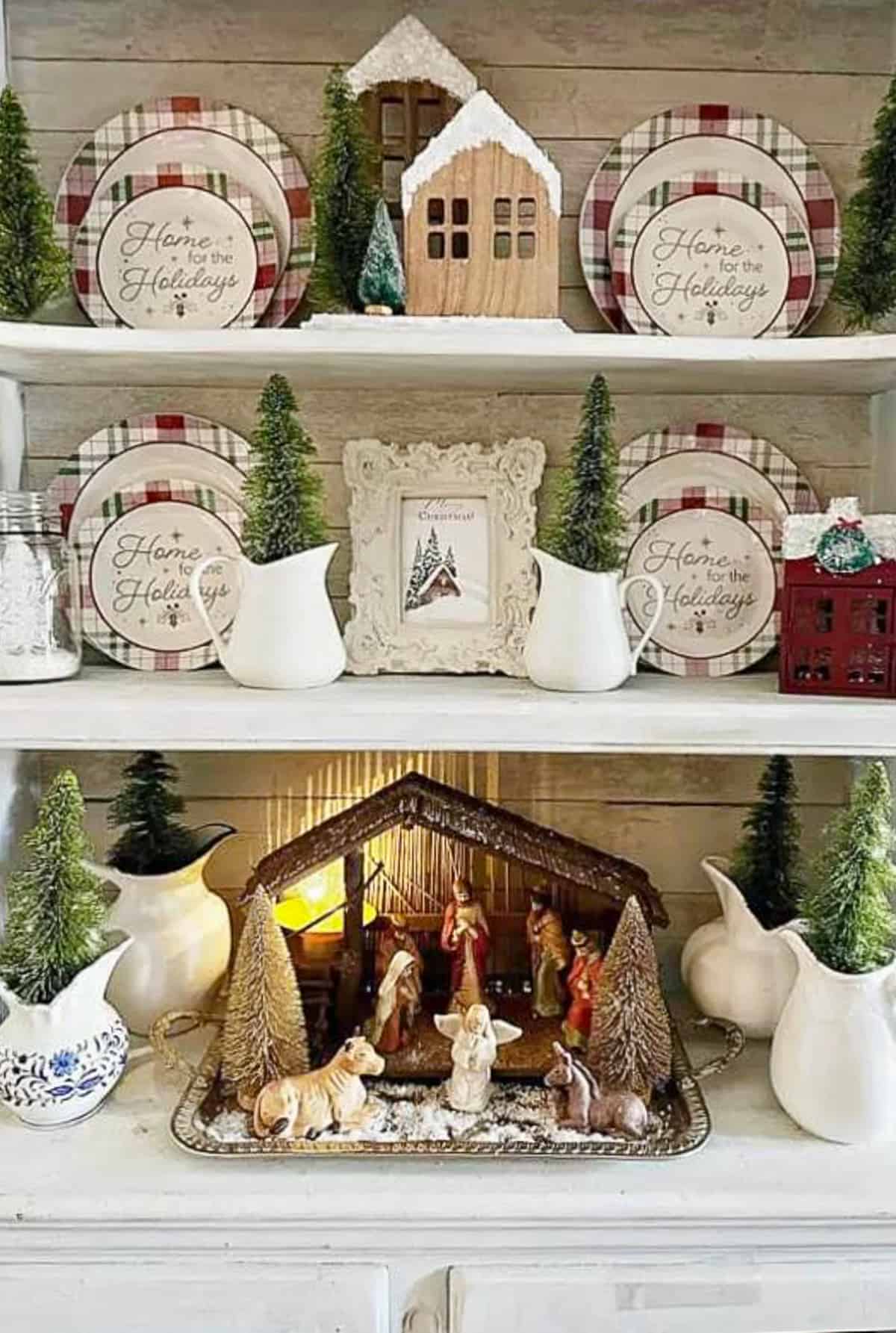 nativity set in a creche on shelves filled with plates