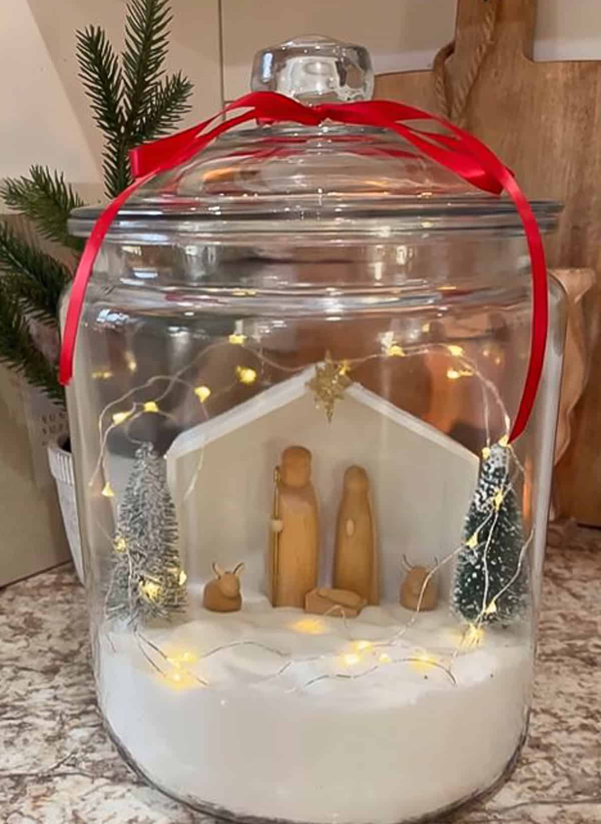 small nativity displayed in a glass canister