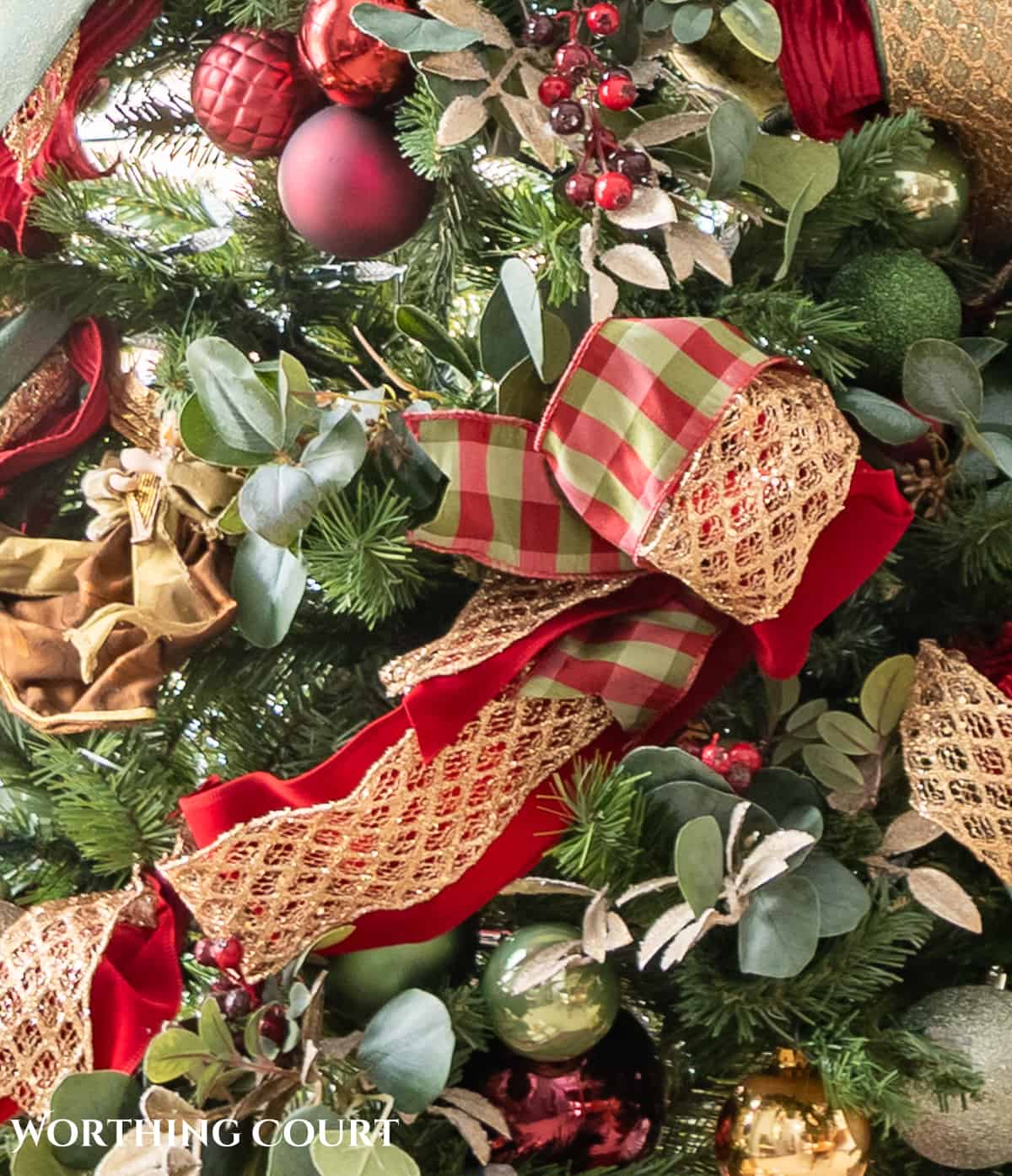 burgundy, green and gold Christmas ribbons and decorations on a Christmas tree