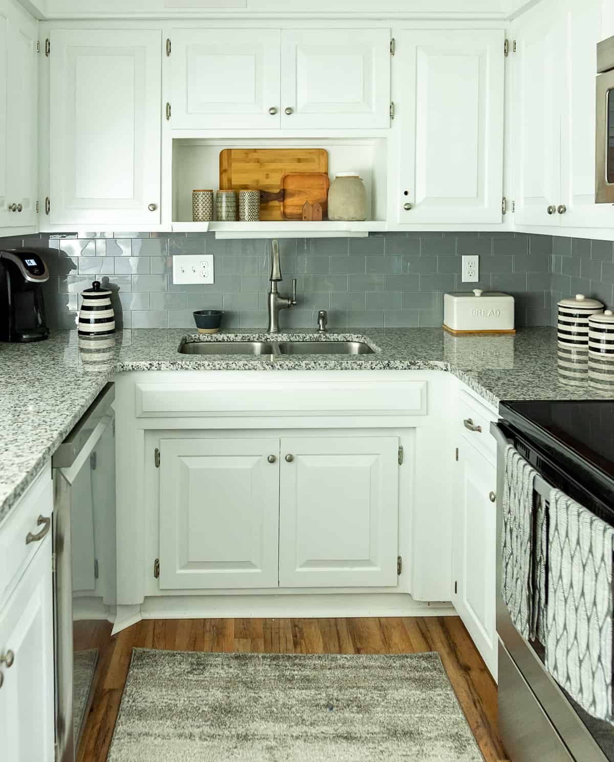 U shaped kitchen with white cabinets and granite counters