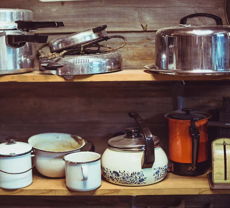wood shelves filled with various pots and pans