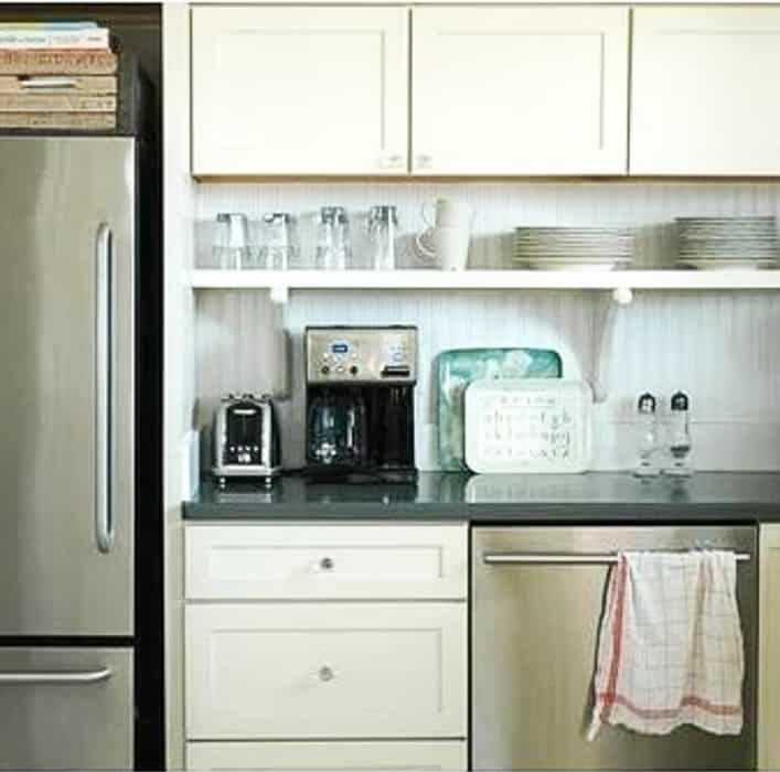 diy shelf below white kitchen cabinets beside a stainless refrigerator