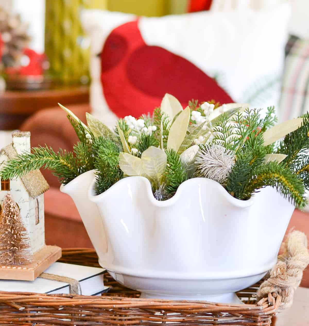 white bowl on a coffee table decorated for winter with faux greenery