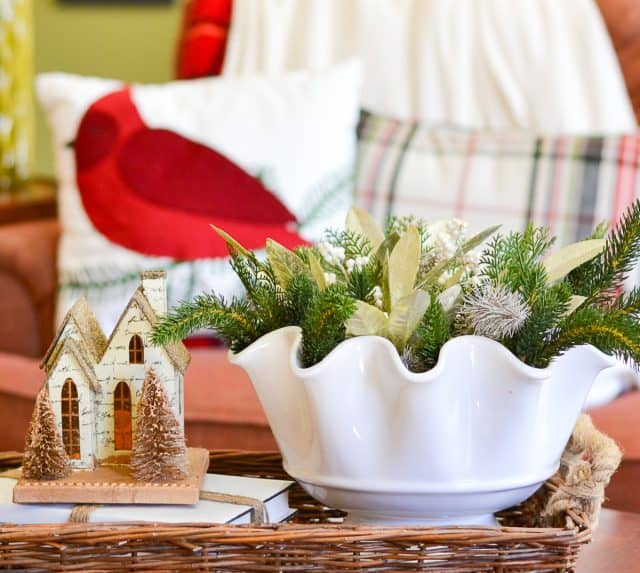white bowl on a coffee table decorated for winter with faux greenery