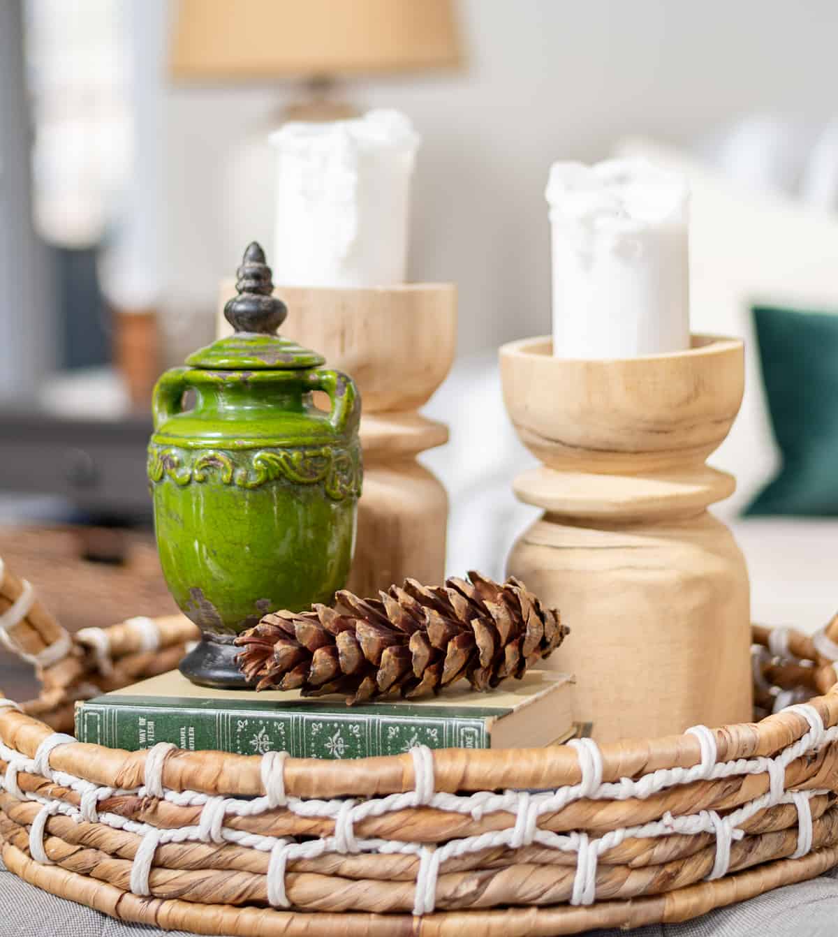 winter vignette in a wicker tray usingh greena nd white, candles and pinecones