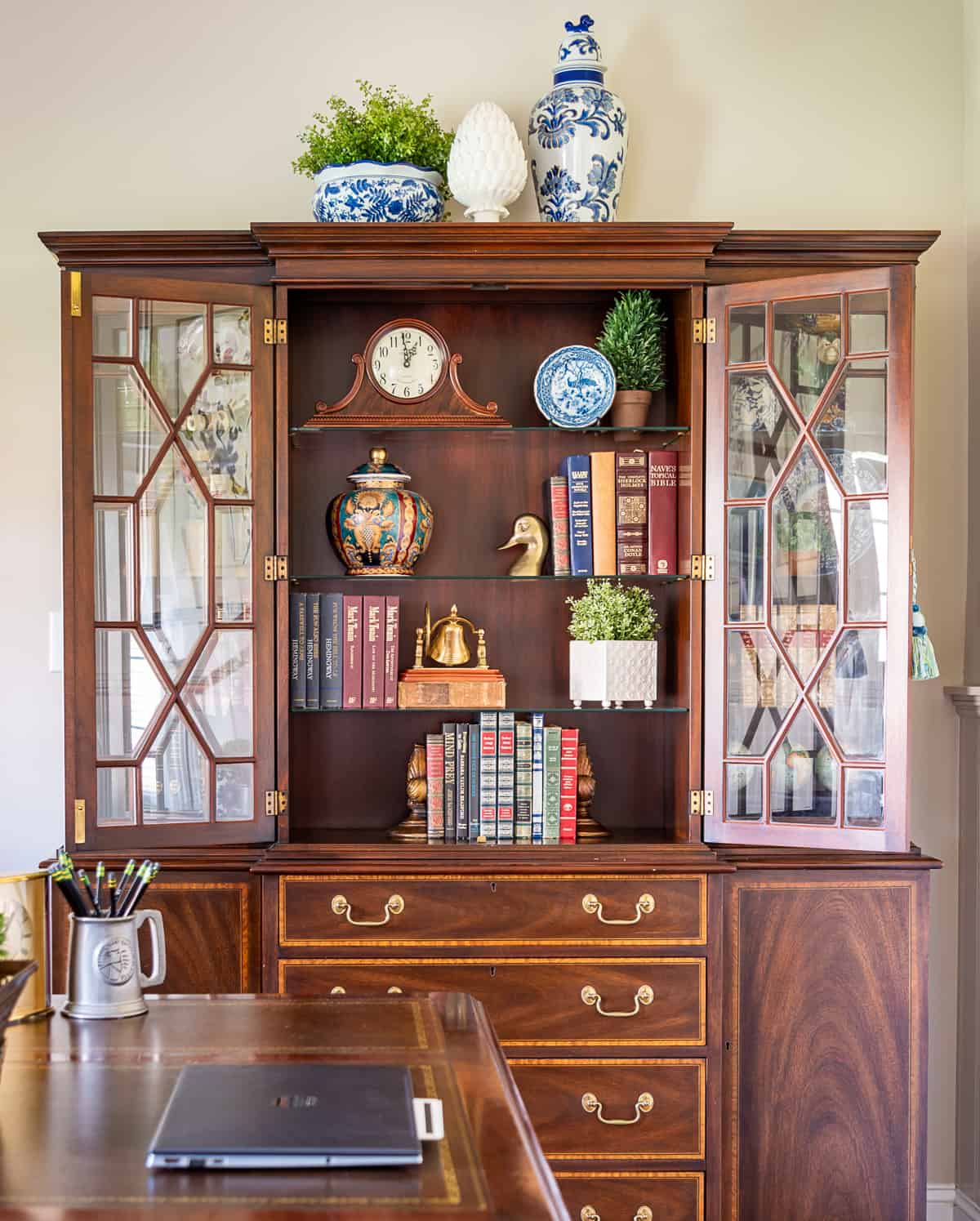 China cabinet in a home office filled with office type accessories - very on trend for 2024