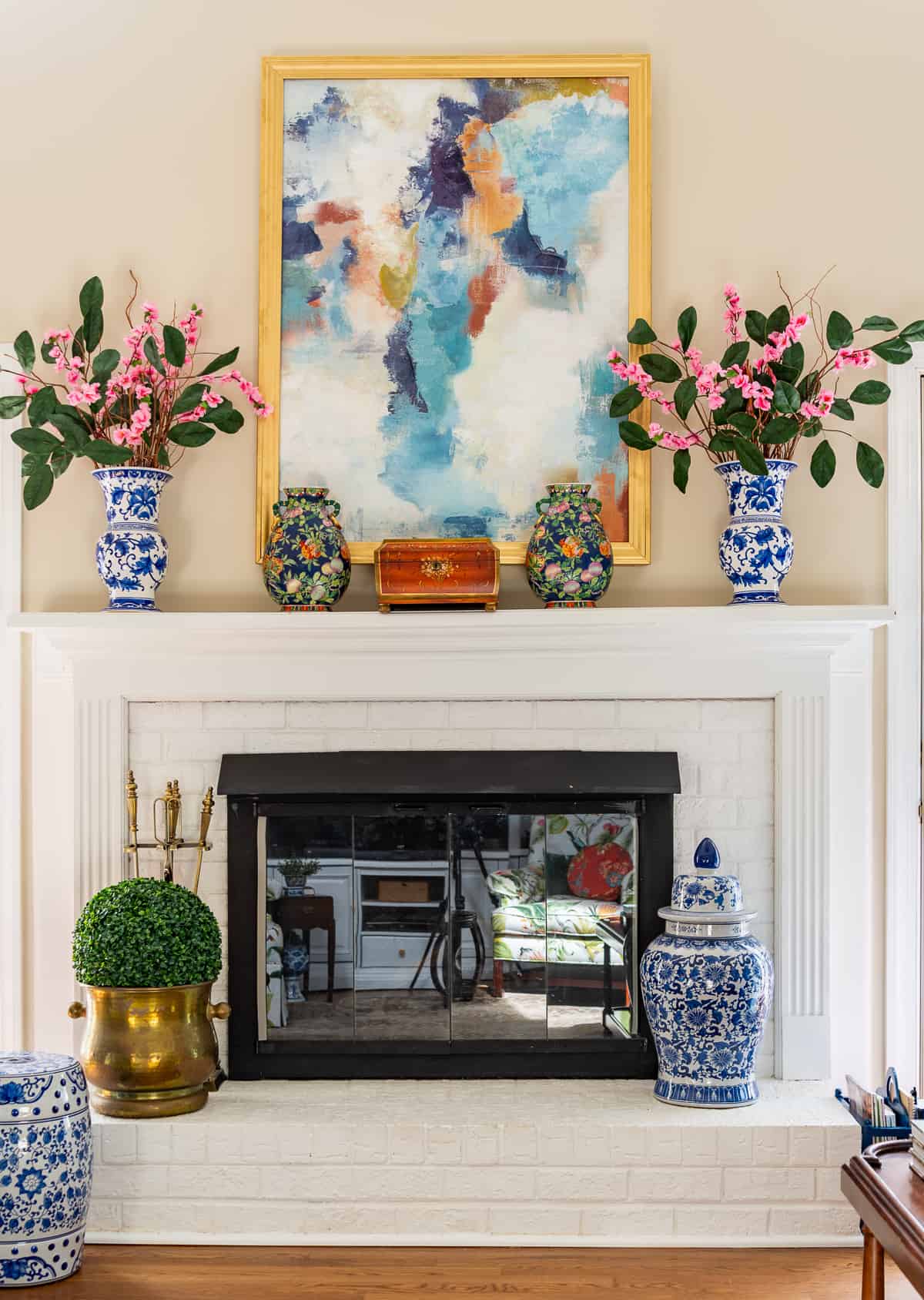 fireplace in a living room decorated in new traditional style with blue recliners, wood tables, colorful accessories and a faux antelope area rug