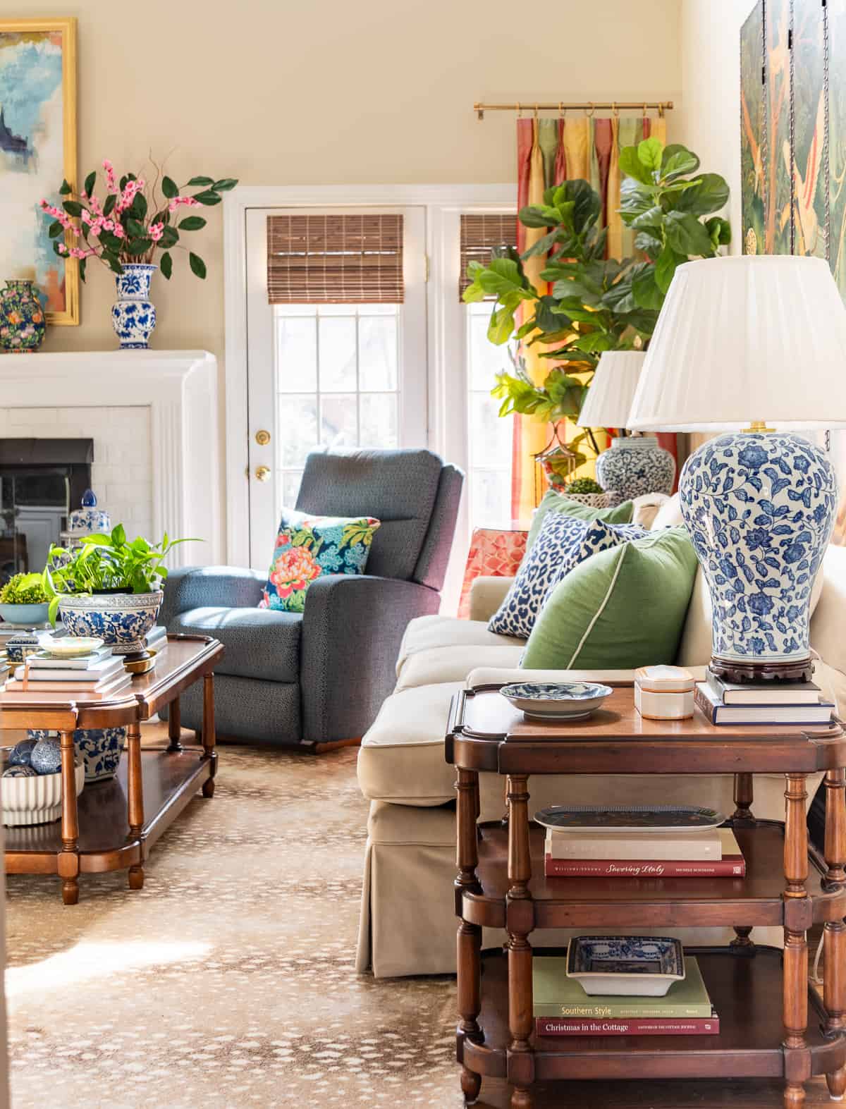 fireplace in a living room decorated in new traditional style with blue recliners, wood tables, colorful accessories and a faux antelope area rug