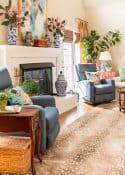 coice of antelope area rug in front of fireplace in a living room decorated in new traditional style with blue recliners, wood tables, colorful accessories