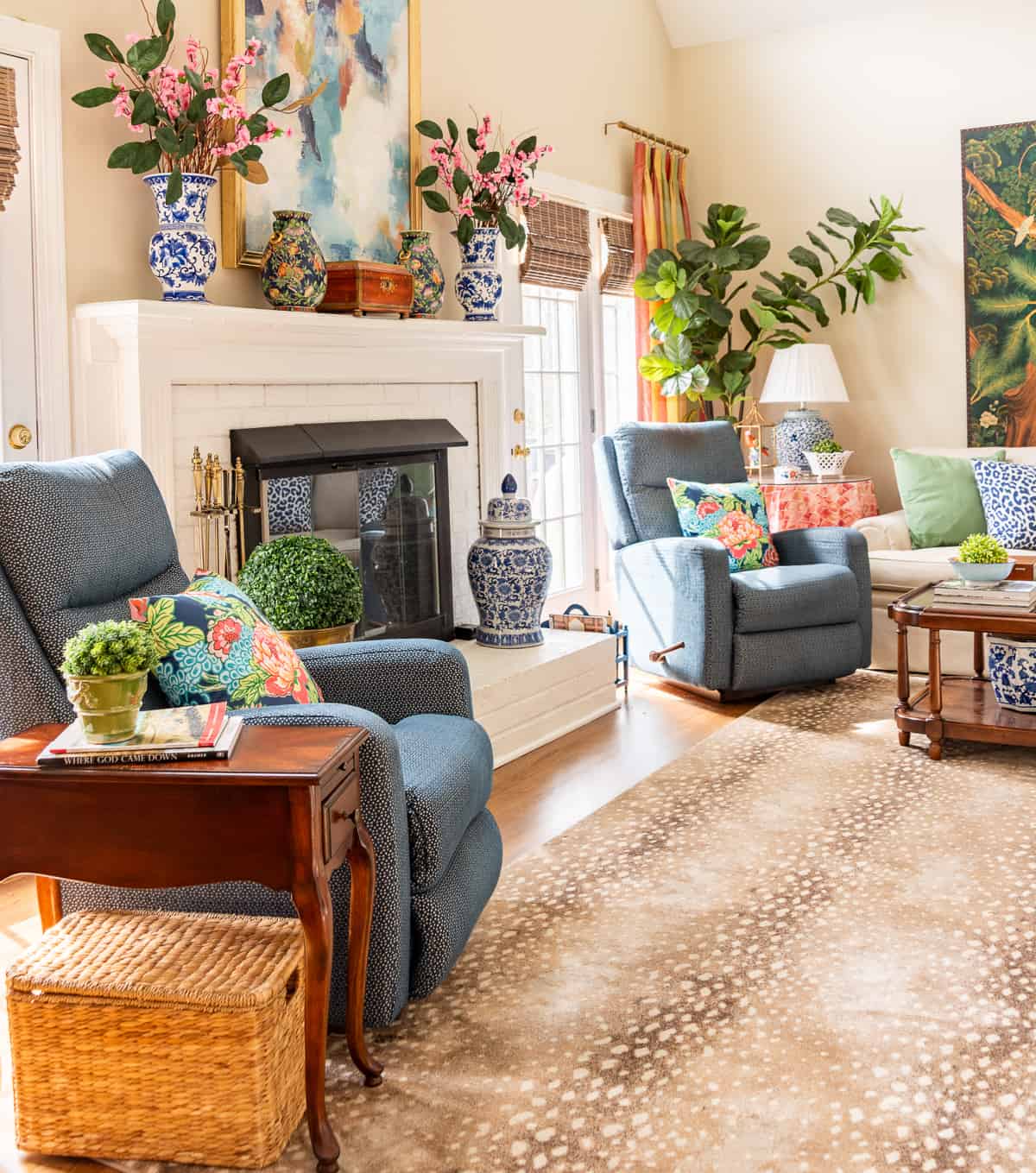 fireplace in a living room decorated in new traditional style with blue recliners, wood tables, colorful accessories and a faux antelope area rug