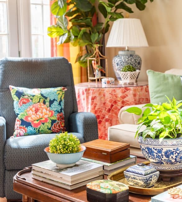 a variety of colorful accessories in a new traditional style living room on tables around a blue recliner
