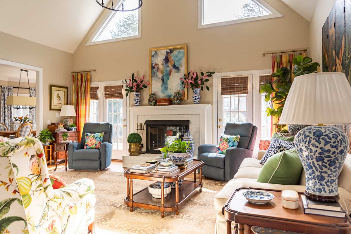 fireplace in a living room decorated in new traditional style with blue recliners, wood tables, colorful accessories and a faux antelope area rug