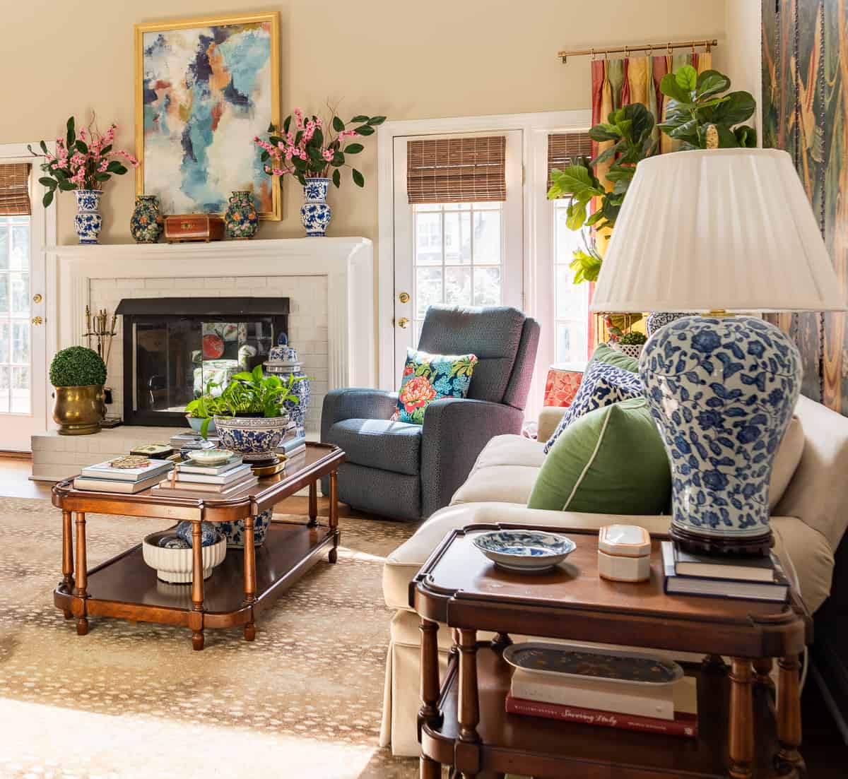 fireplace in a living room decorated in new traditional style with blue recliners, wood tables, colorful accessories and a faux antelope area rug