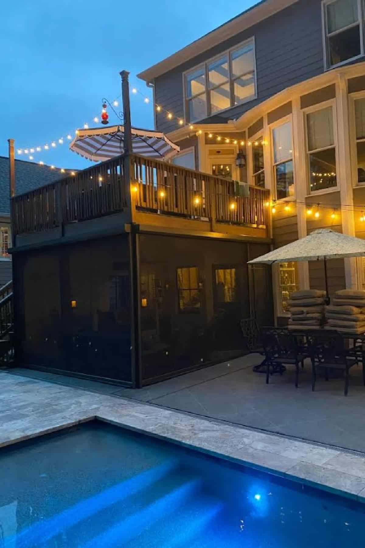 nighttime image of deck with screen porch underneath