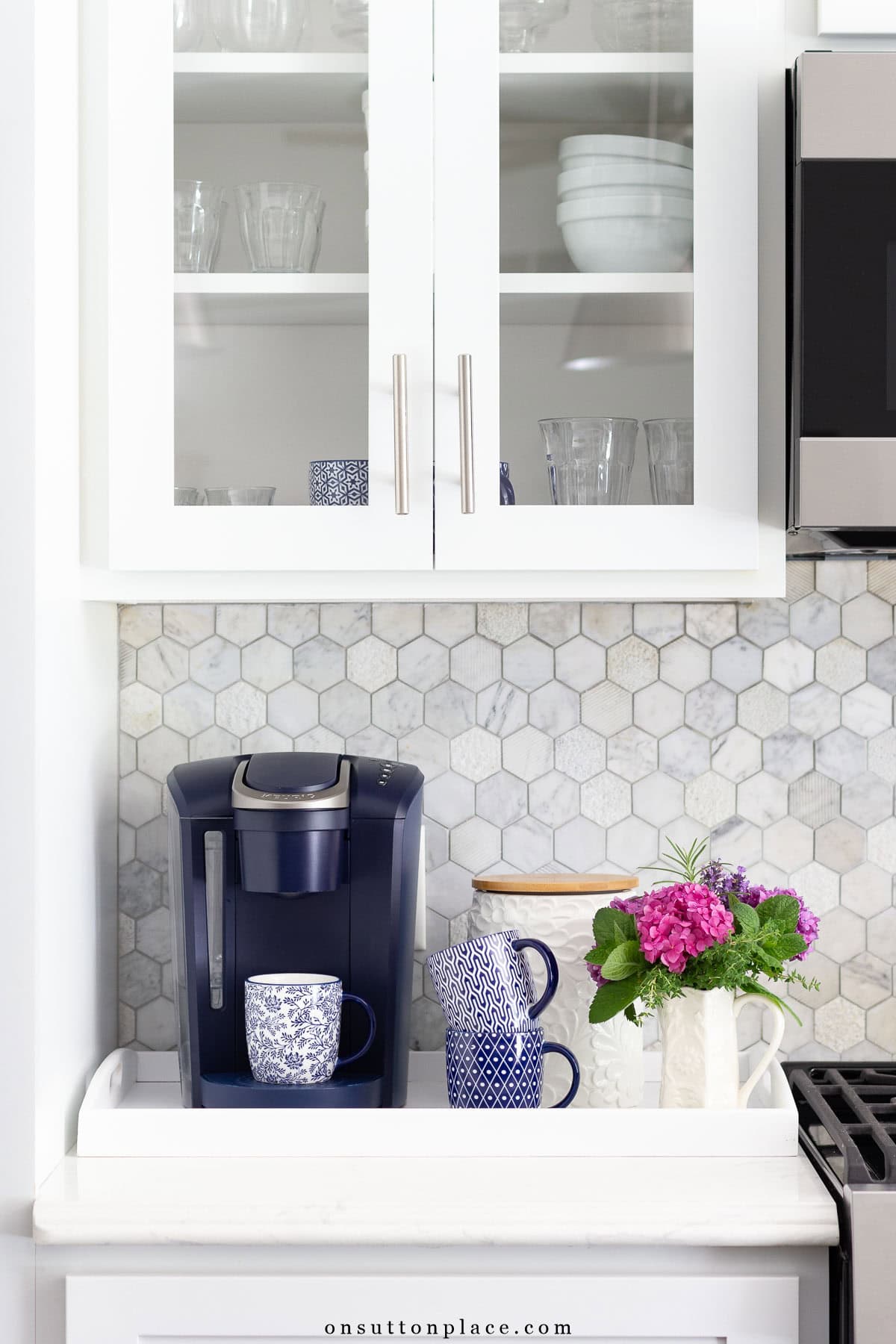 coffee station on a kitchen counter with white cabinets