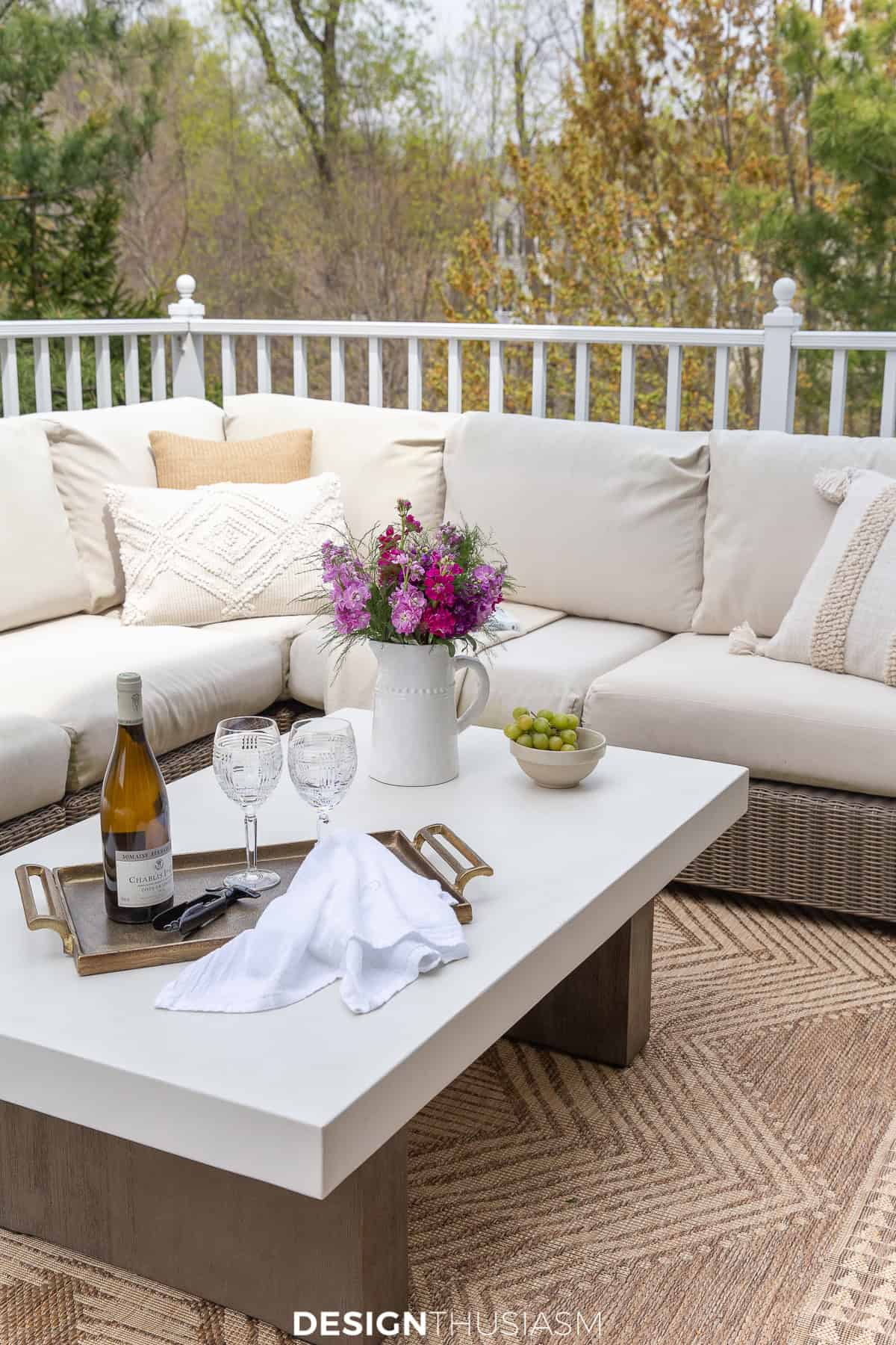 white sectional sofa and white topped coffee table on a deck