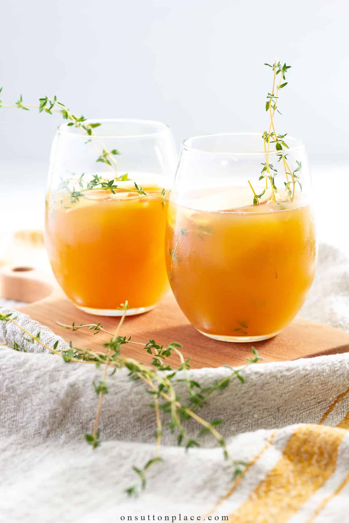 two stemless wine glasses filled with an orange mocktail
