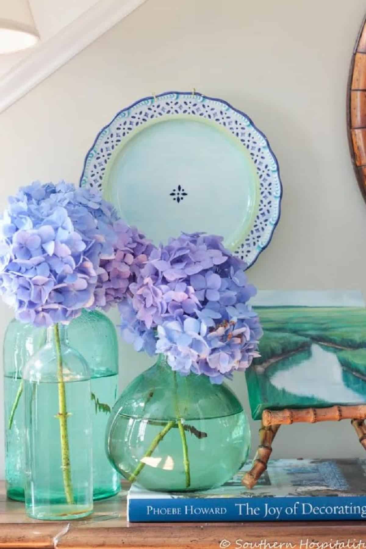 blue hydrangea blossoms in green glass vases