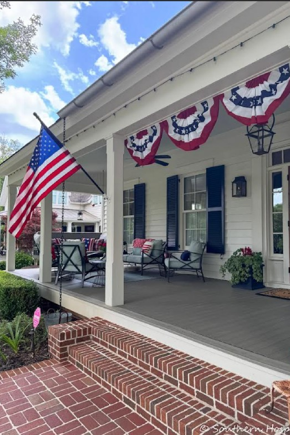 front porch with patriotic bunting and an American flag 