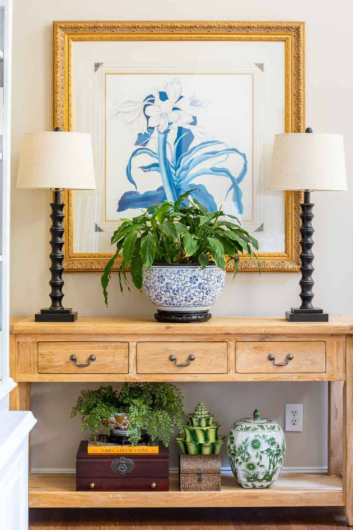unfinished pine console table with a pair of lamps and a large plant in a blue and white container