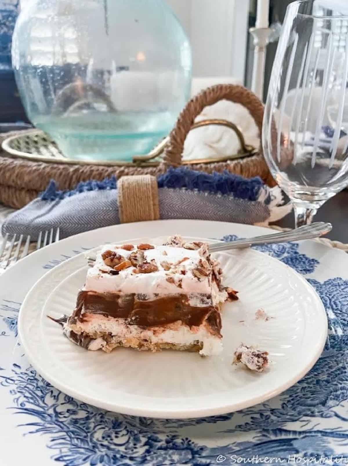 single pieces of chocolate yum yum dessert topped with chopped pecans on a white plate
