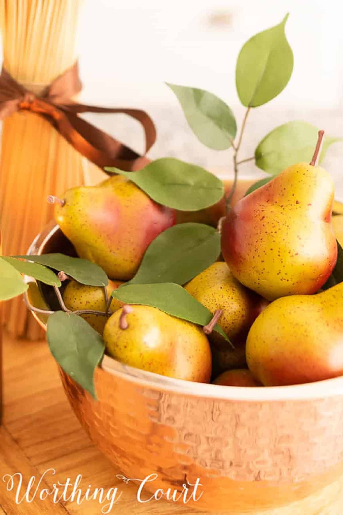copper bowl filled with small faux pears