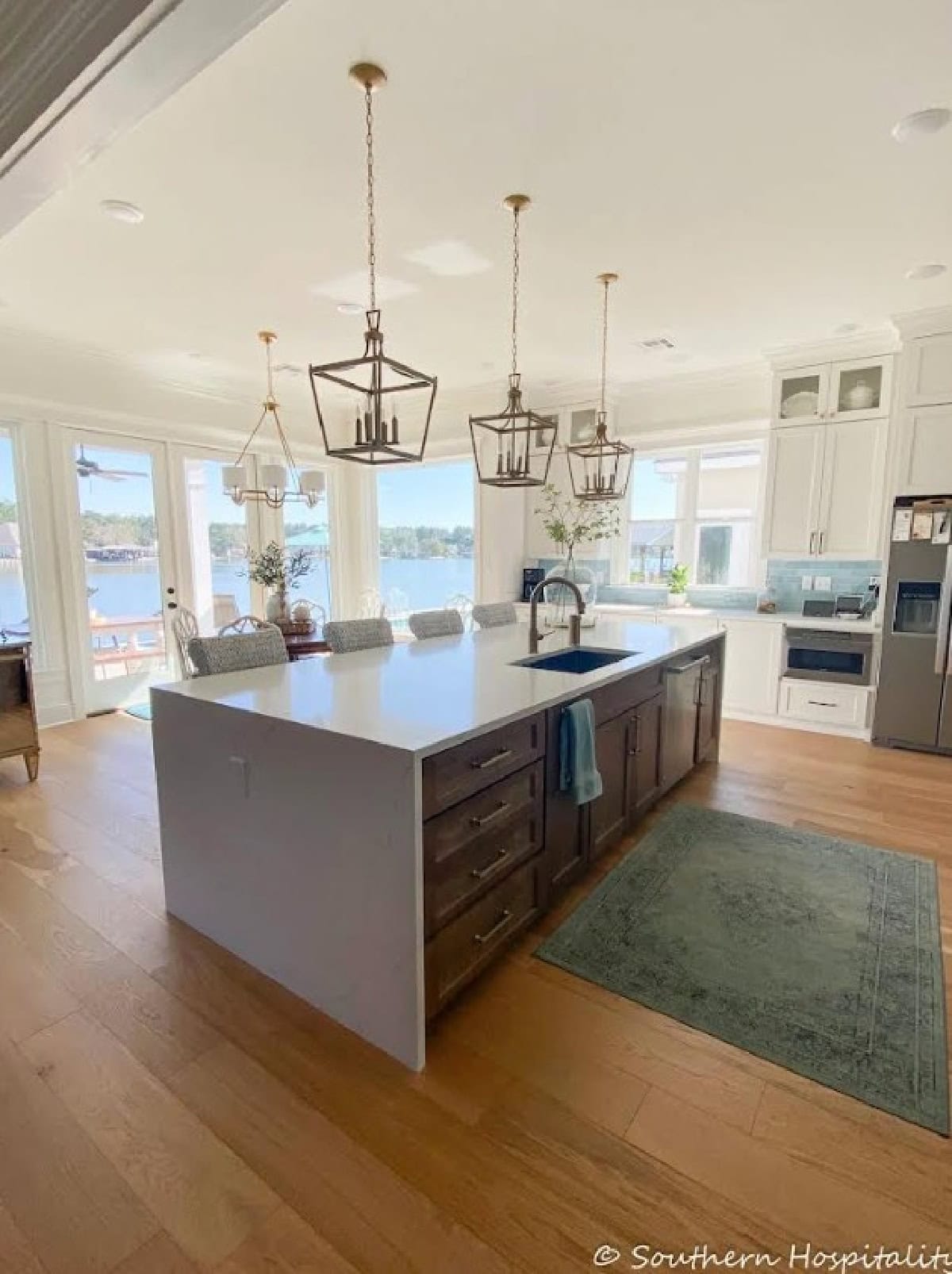 kitchen with a large gray island in an open floor plan house overlooking a lake