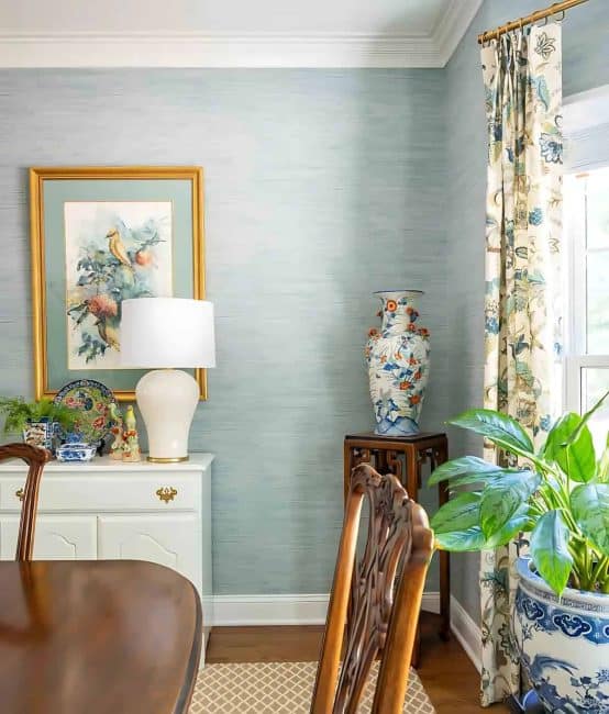 partial view of a dining room with blue grasscloth wallpaper and traditional decor