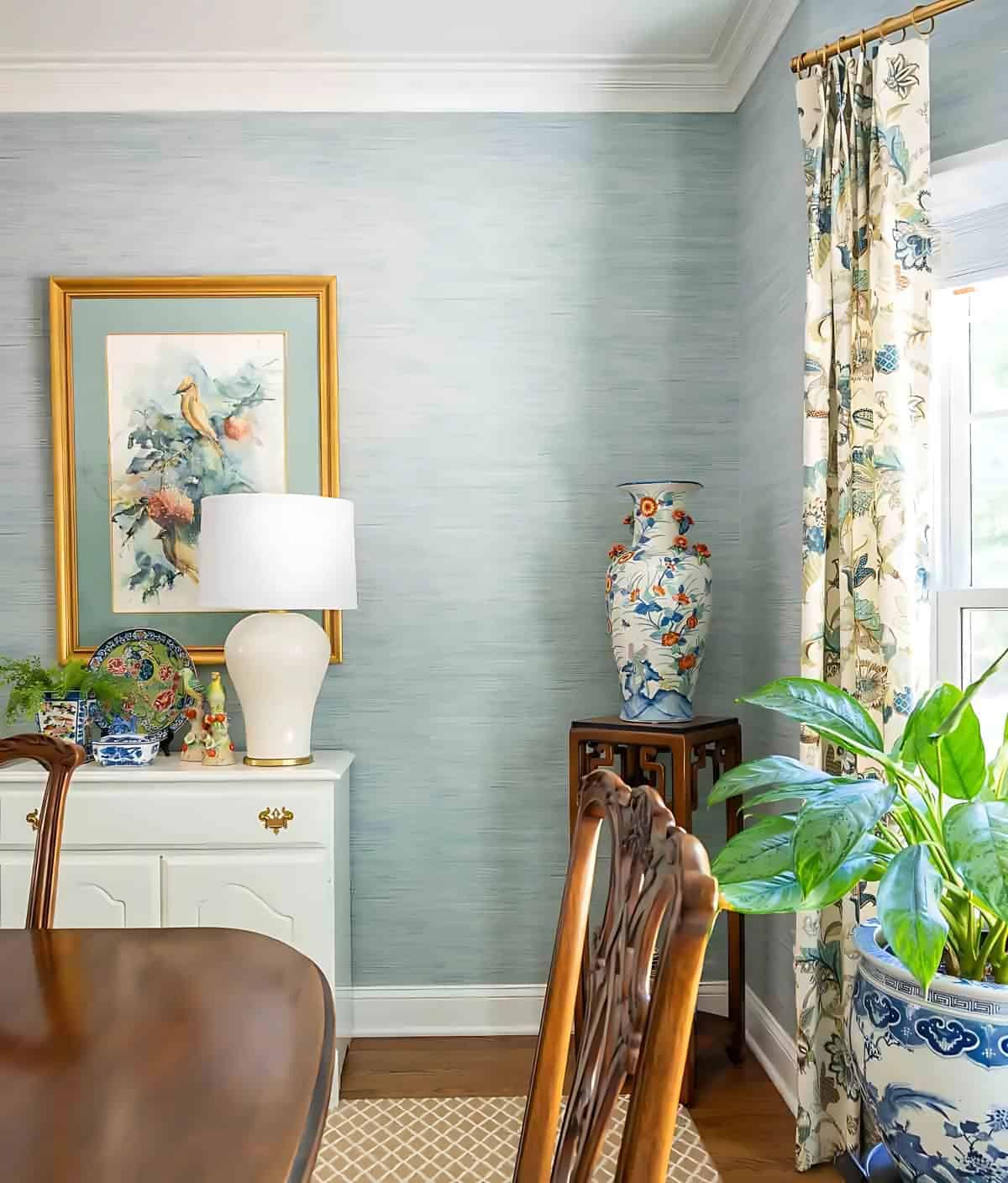 partial view of a dining room with blue grasscloth wallpaper and traditional decor